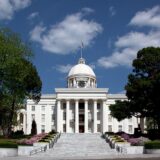 The first Capitol building in Montgomery, Alabama was built in 1847, and was destroyed by fire in 1849. The current State Capitol was built on the previous Capitol's foundations, and was completed in 1851. The building has grown over time with an east wing added to the buildings rear in 1885, a south wing in 1906, a matching north wing in 1912, and along with a complete renovation to the whole building a modern addition to the rear in 1992.