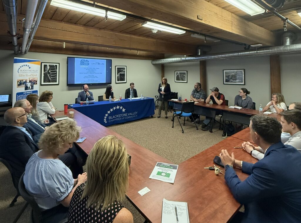 MA Blackstone 060426 eNews image - NFIB Business meeting in a conference room with a speaker at the front beside a projector screen and Blackstone Valley Chamber of Commerce banner.