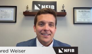 Portrait of Jared Weiser in a blue suit, smiling in an office with NFIB branding and framed diplomas on the wall.