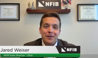 Video still of Jared Weiser, NFIB State Director for Ohio, speaking at a desk with framed diplomas on the wall and NFIB signage, plus a green lower-third displaying his name and title.
